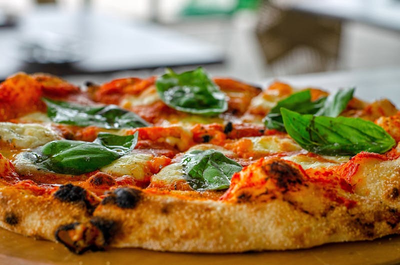 Margherita thin crust pizza with fresh basil and tomato